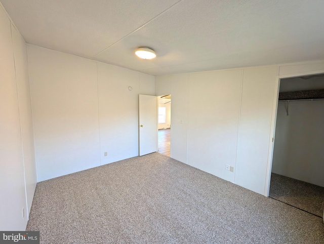 unfurnished bedroom with a closet, carpet, and a textured ceiling