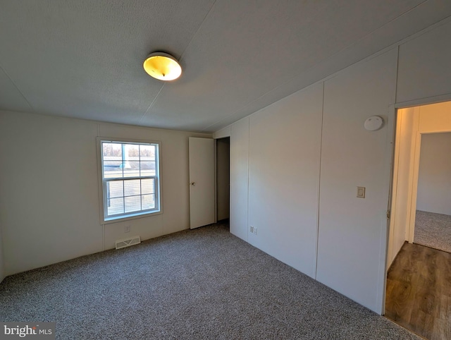 spare room with hardwood / wood-style floors and a textured ceiling