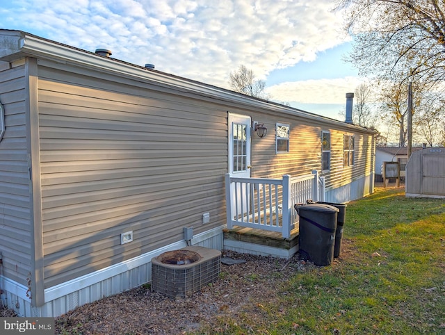 back of property with a lawn and cooling unit