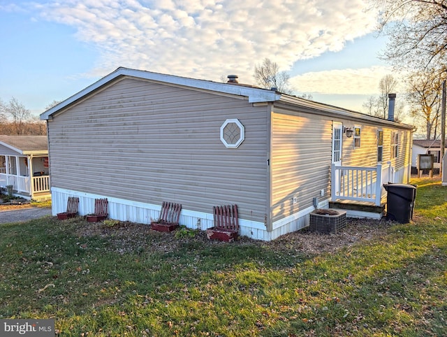 view of side of property featuring a lawn and central air condition unit