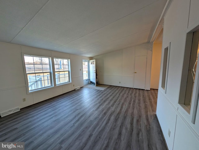 unfurnished room featuring lofted ceiling and dark wood-type flooring