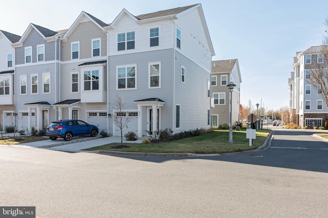 multi unit property featuring a garage and a front yard