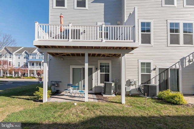 back of house featuring central air condition unit, a patio area, and a yard