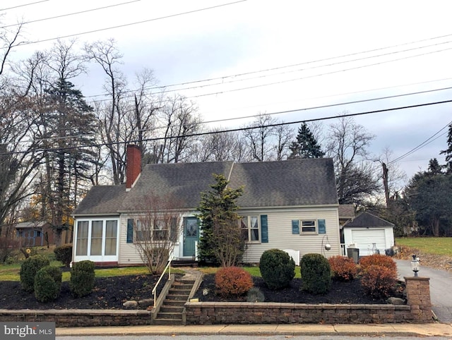 view of front of property featuring a garage and an outdoor structure