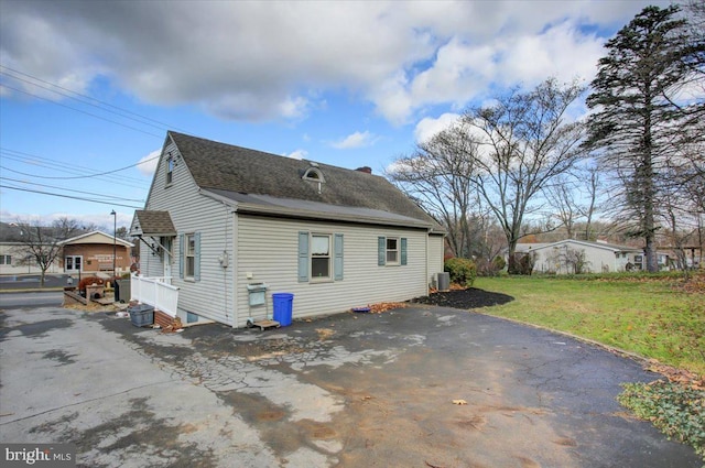 view of side of property featuring a yard and central AC unit