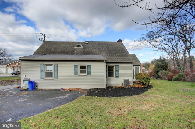 rear view of house with a yard and central AC unit