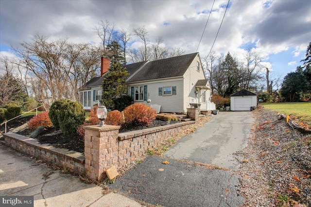 view of front of home with a garage and an outbuilding