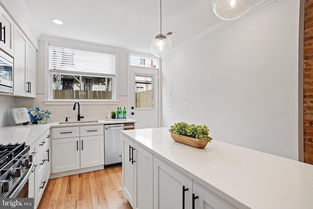 kitchen with white cabinetry, sink, stainless steel appliances, and plenty of natural light