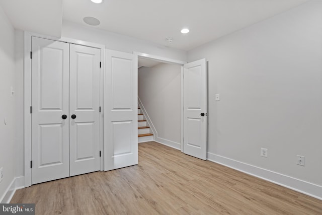 unfurnished bedroom featuring light hardwood / wood-style floors and a closet