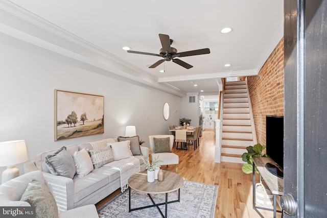 living room with ceiling fan, light hardwood / wood-style flooring, and ornamental molding