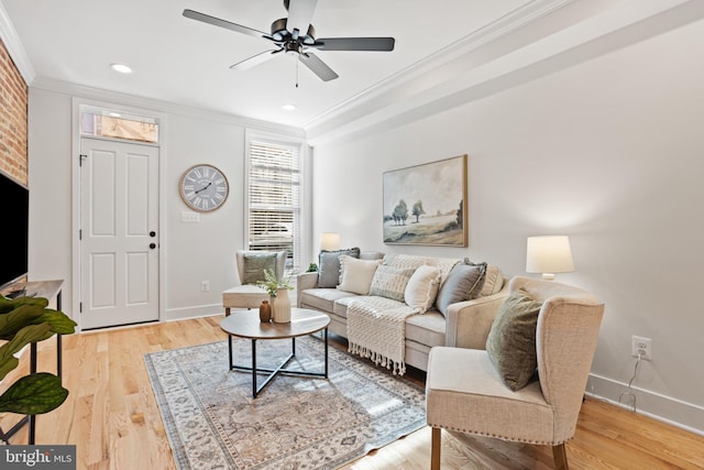 living room with a fireplace, hardwood / wood-style floors, ceiling fan, and crown molding