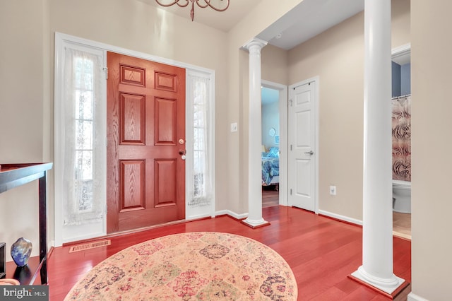 foyer entrance featuring ornate columns and wood-type flooring