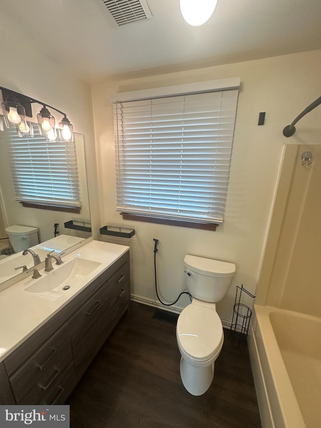 full bathroom featuring vanity, wood-type flooring, bathtub / shower combination, and toilet