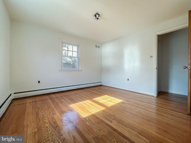 spare room featuring light hardwood / wood-style flooring and a baseboard heating unit