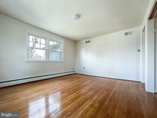 spare room with light wood-type flooring and a baseboard radiator