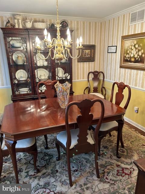 dining space featuring ornamental molding and an inviting chandelier