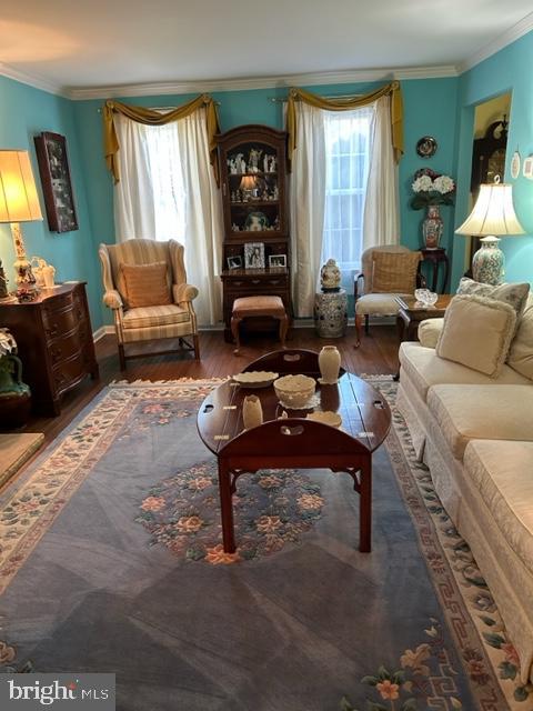 sitting room with hardwood / wood-style flooring and ornamental molding