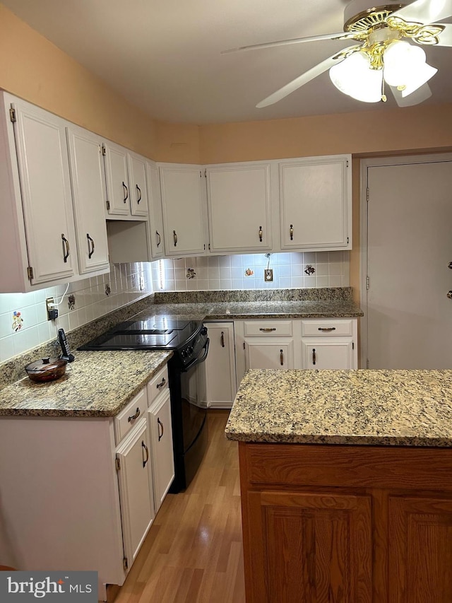 9221 Greenhouse Cir, Nottingham, MD 21236 - kitchen featuring black electric range oven, light stone counters, white cabinetry, tasteful backsplash, and ceiling fan