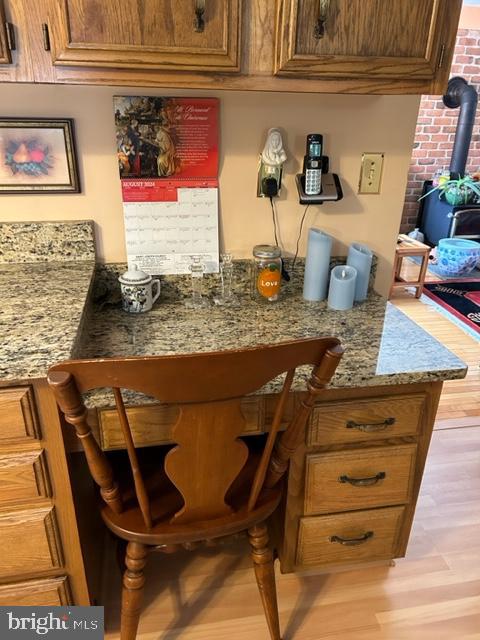 bar featuring stone counters and light hardwood / wood-style floors