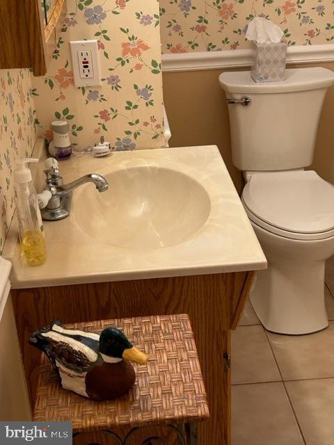 9221 Greenhouse Cir, Nottingham, MD 21236 - half bathroom with wallpapered walls, a wainscoted wall, tile patterned floors, and vanity