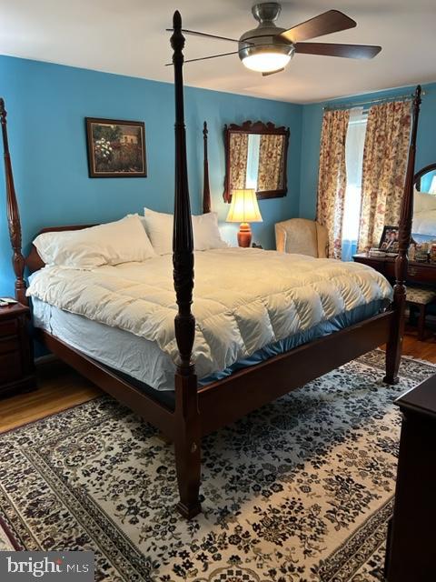 bedroom with ceiling fan and wood-type flooring