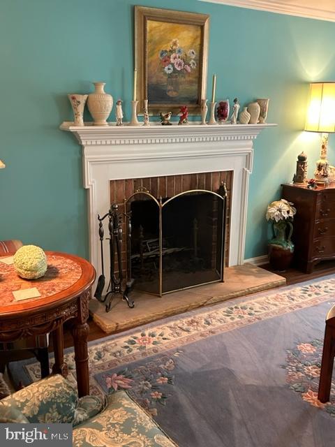 sitting room with a fireplace and crown molding