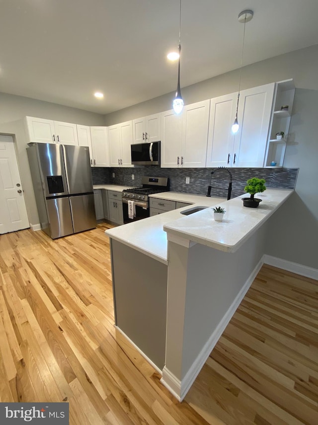 365 Union Aly, Pottstown, PA 19464 - kitchen featuring stainless steel appliances, a sink, a peninsula, light countertops, and light wood-style floors