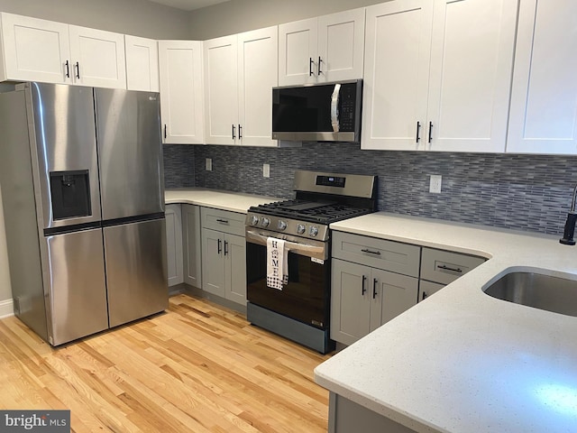 365 Union Aly, Pottstown, PA 19464 - kitchen with appliances with stainless steel finishes, a sink, light wood finished floors, and decorative backsplash