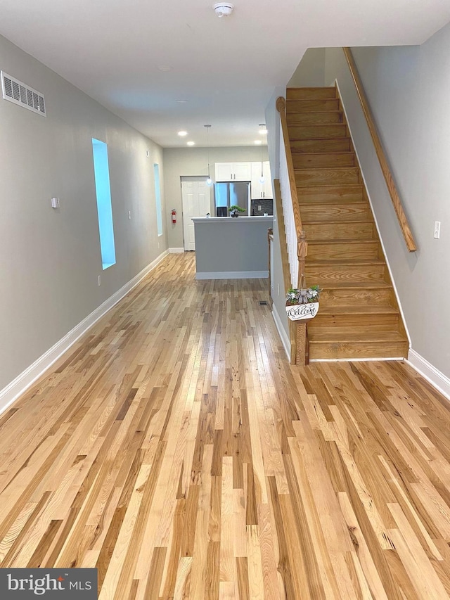 365 Union Aly, Pottstown, PA 19464 - unfurnished living room with light wood-style flooring, stairway, and baseboards
