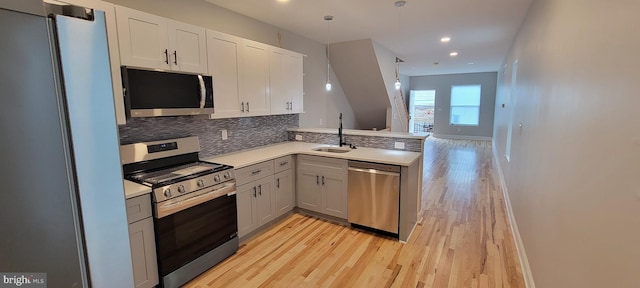 kitchen featuring sink, white cabinets, gray cabinets, light hardwood / wood-style floors, and stainless steel appliances