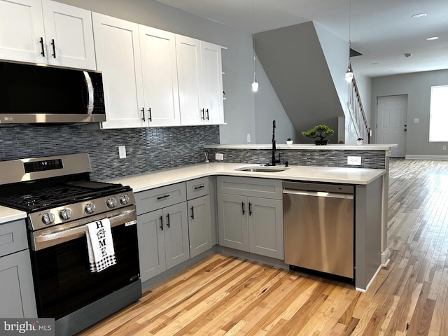 365 Union Aly, Pottstown, PA 19464 - kitchen with appliances with stainless steel finishes, a sink, gray cabinetry, a peninsula, and light wood-type flooring