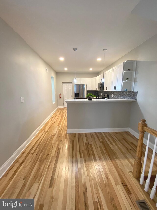 365 Union Aly, Pottstown, PA 19464 - kitchen with appliances with stainless steel finishes, light wood-type flooring, white cabinets, a peninsula, and decorative light fixtures