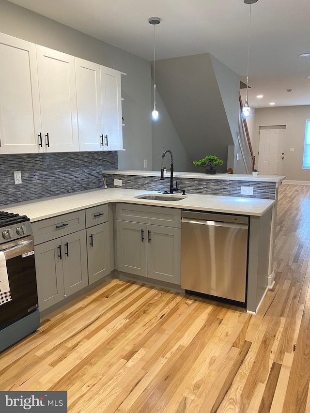 365 Union Aly, Pottstown, PA 19464 - kitchen with appliances with stainless steel finishes, a sink, gray cabinetry, light wood-style floors, and a peninsula