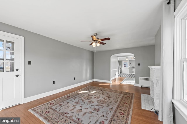 foyer entrance with radiator heating unit, ceiling fan, and hardwood / wood-style floors