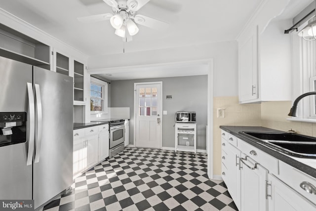 kitchen with stainless steel appliances, white cabinetry, ceiling fan, and sink