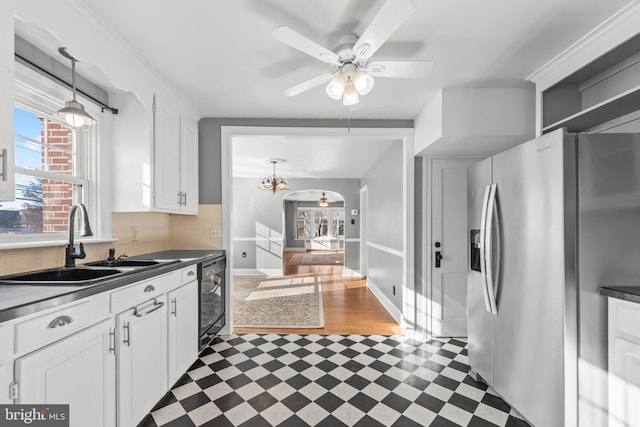 kitchen featuring white cabinetry, stainless steel fridge, sink, and ceiling fan with notable chandelier