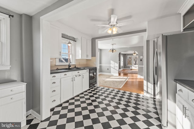 kitchen featuring ceiling fan, sink, white cabinets, dark hardwood / wood-style floors, and stainless steel refrigerator