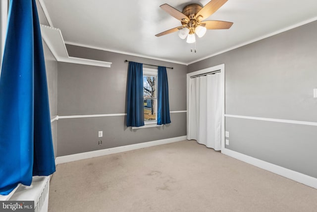 unfurnished bedroom with a closet, ceiling fan, crown molding, and light colored carpet