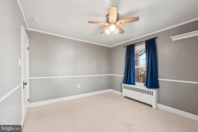 carpeted empty room with radiator, crown molding, and ceiling fan