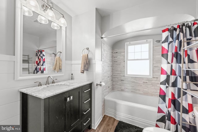 bathroom with shower / tub combo with curtain, vanity, wood-type flooring, and tile walls