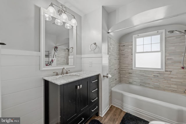 bathroom featuring vanity, wood-type flooring, and tiled shower / bath combo