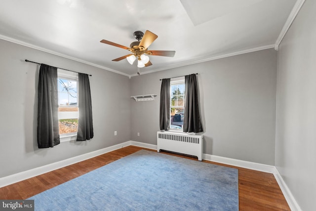 spare room with ceiling fan, wood-type flooring, radiator heating unit, and ornamental molding