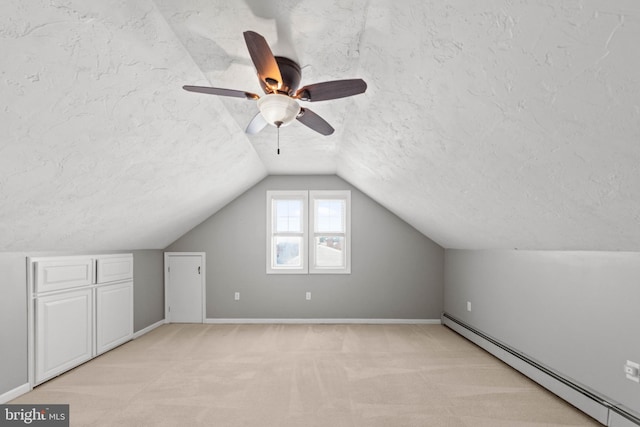 additional living space with baseboard heating, light carpet, vaulted ceiling, and a textured ceiling