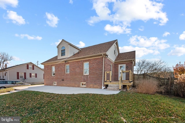 view of side of property featuring a yard and a patio