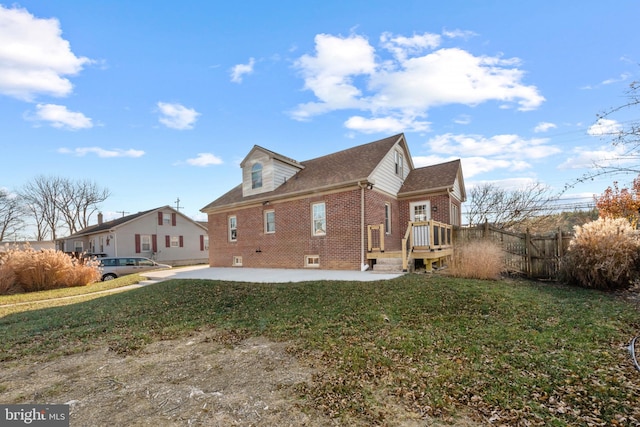 rear view of house featuring a patio area and a yard