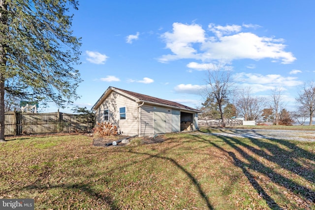 view of property exterior featuring an outbuilding and a lawn