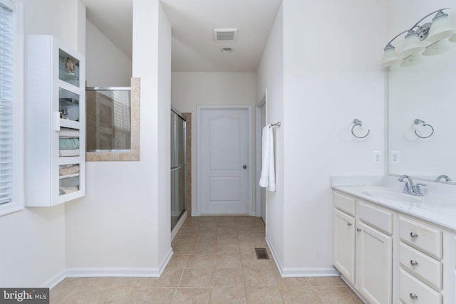 bathroom featuring tile patterned flooring, vanity, and a shower with shower door