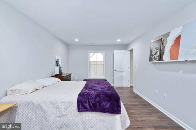 bedroom with dark hardwood / wood-style floors