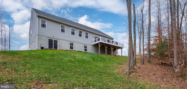 rear view of house with a yard and a wooden deck