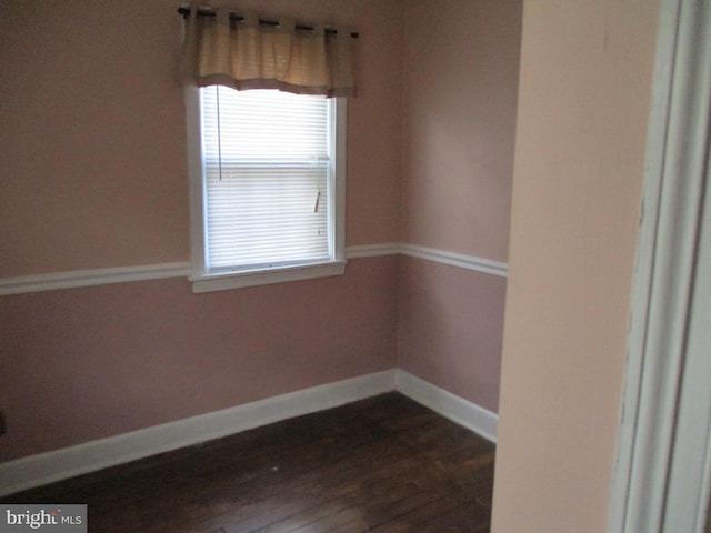 unfurnished room with dark wood-type flooring